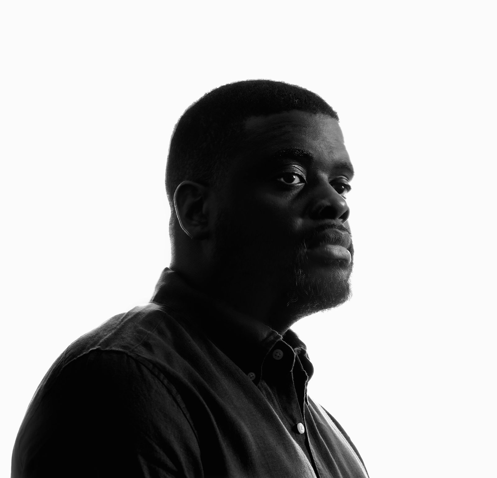 Kevin Grandison in black and white, looking back over his shoulder