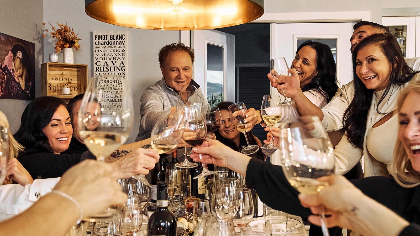 Guests raising their glasses round a candlelit table